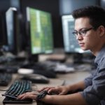 Developer working at a high-performance web development PC workstation with multiple monitors