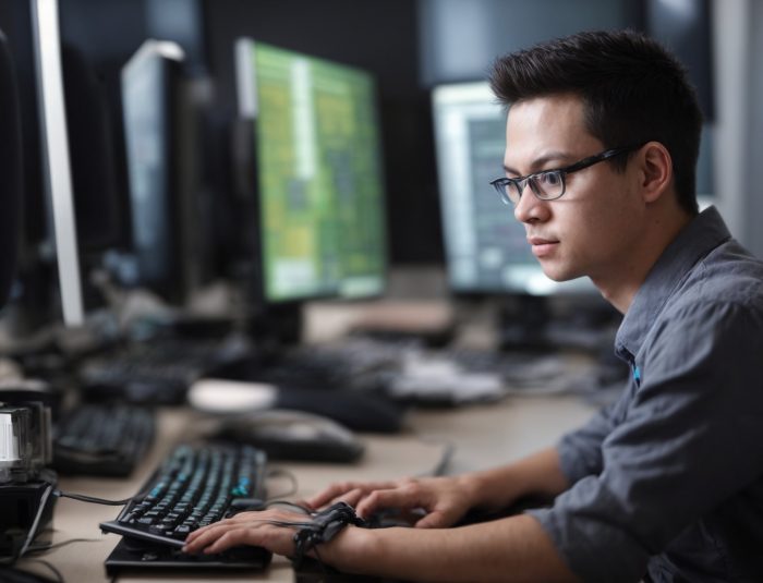 Developer working at a high-performance web development PC workstation with multiple monitors